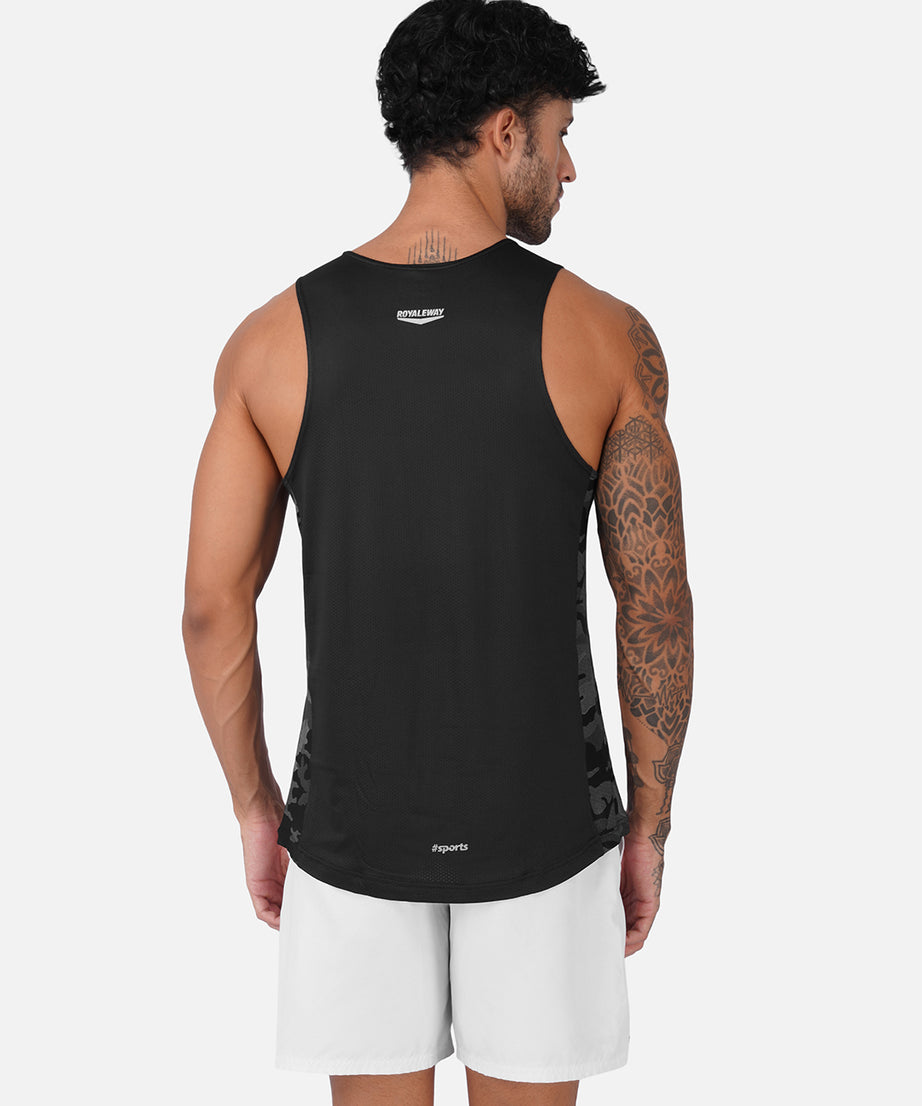 A man shown from the back wearing a black sleeveless athletic tank top and white shorts against a light gray studio background.