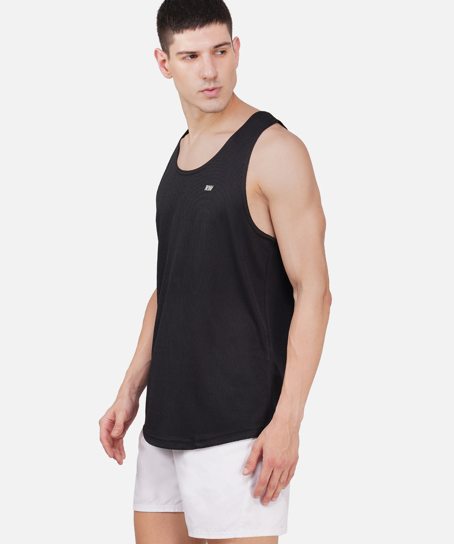 A male model wearing a black sleeveless tank top with a round neckline.