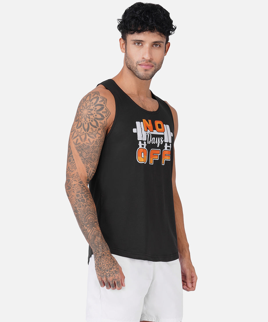 A man wearing a black sleeveless tank top with a graphic that reads 'No Days Off' in orange and white, paired with white shorts, against a light gray studio background.
