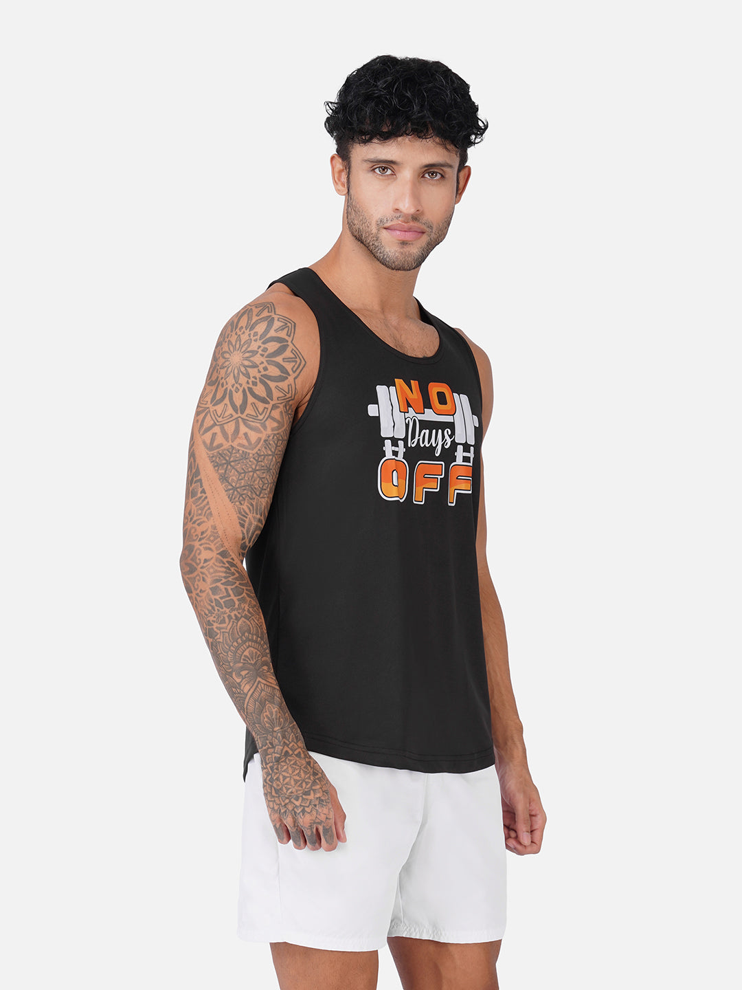 A man wearing a black sleeveless tank top with a graphic that reads 'No Days Off' in orange and white, paired with white shorts, against a light gray studio background.
