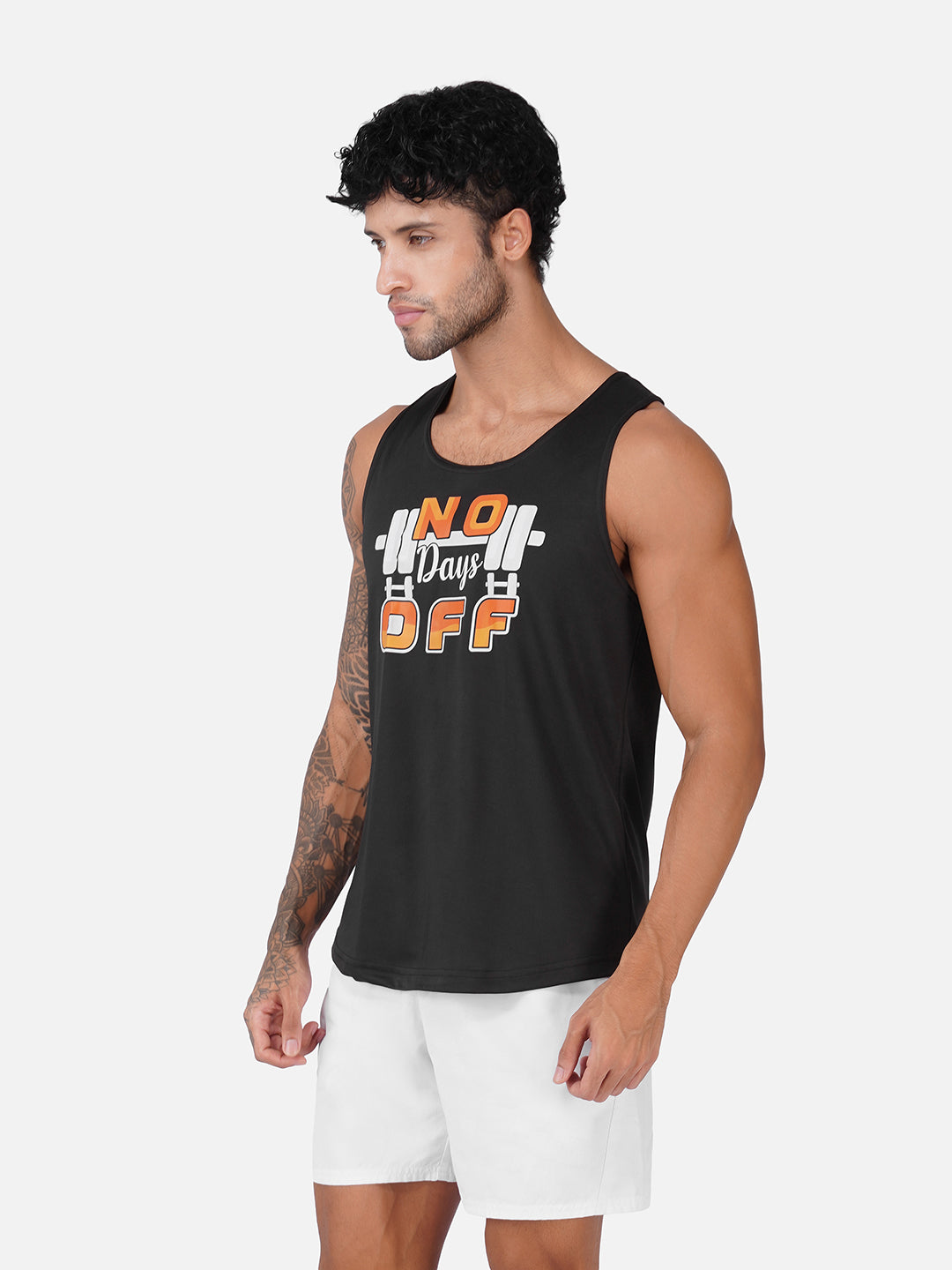 A man wearing a black sleeveless tank top with a white and orange graphic that reads 'No Days Off' with a barbell design, paired with white shorts, against a light gray background.