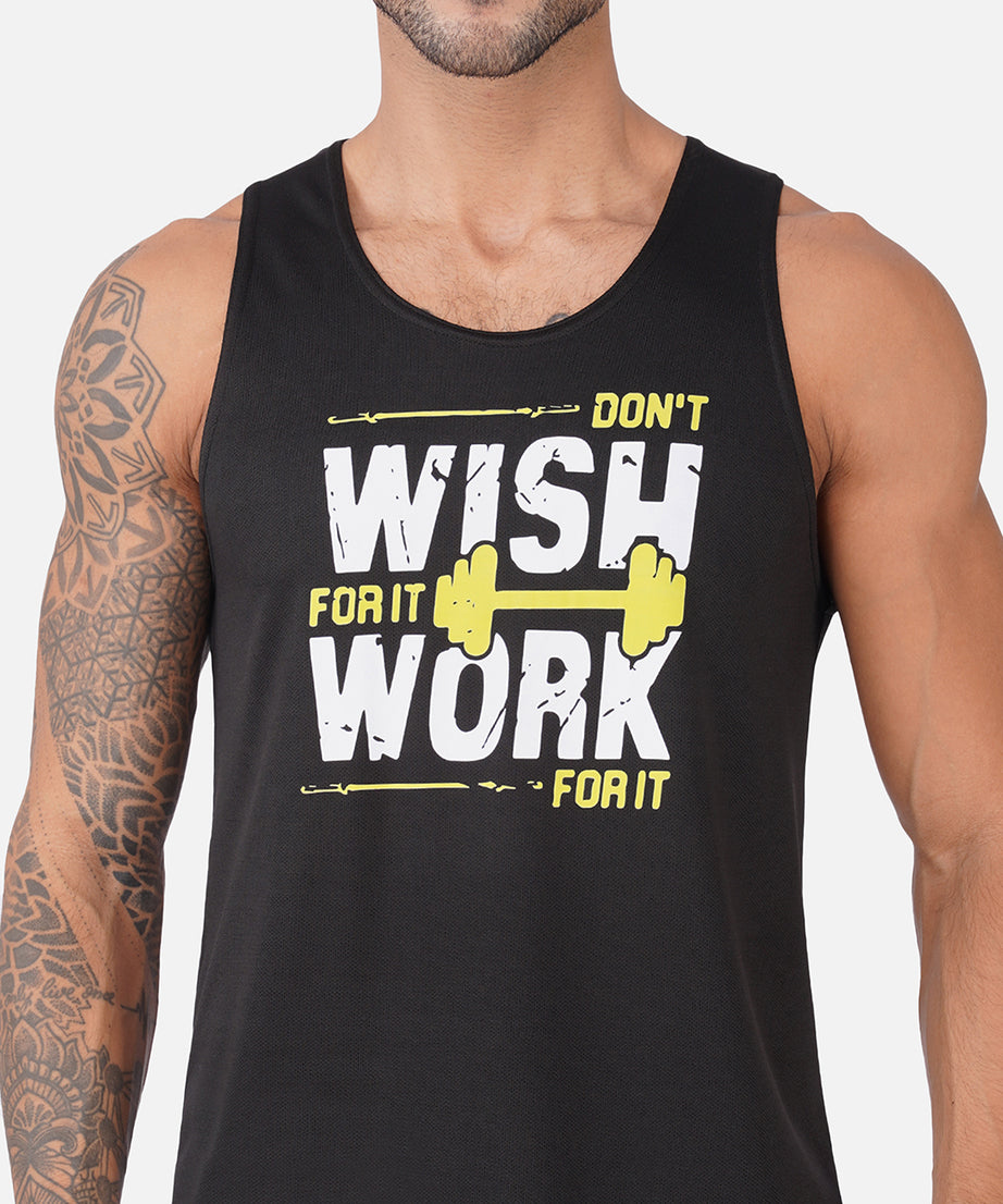 A man wearing a black sleeveless tank top with a bold graphic that reads 'DON'T WISH FOR IT WORK FOR IT' in white and yellow, with a yellow barbell illustration.