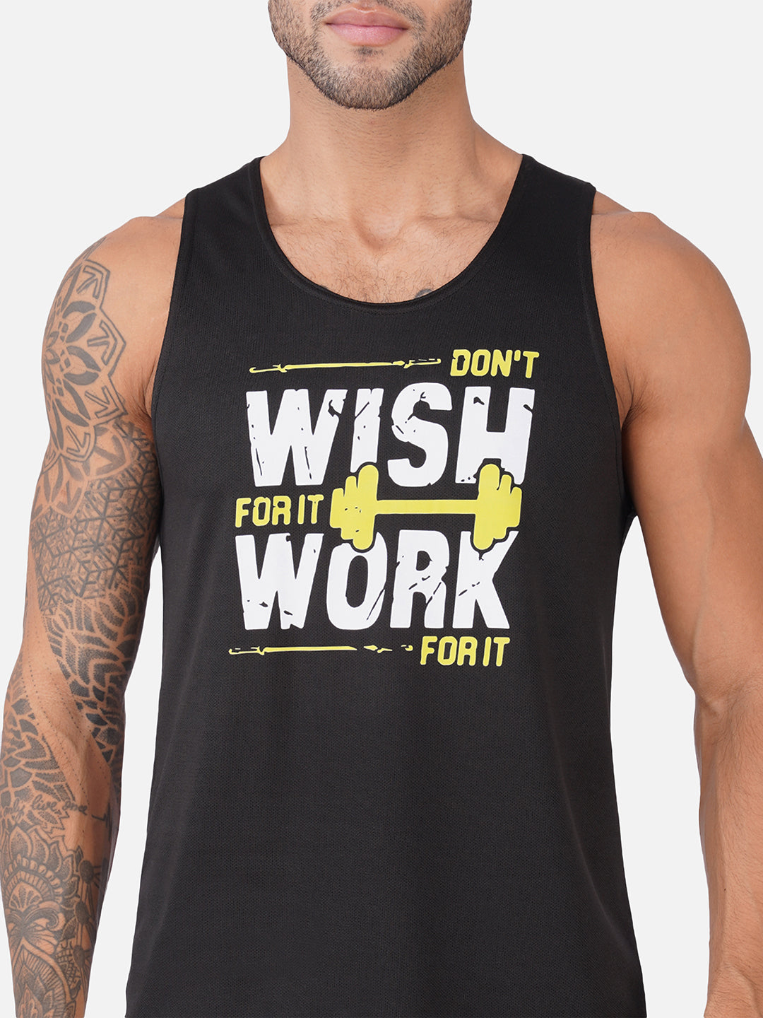 A man wearing a black sleeveless tank top with a bold graphic that reads 'DON'T WISH FOR IT WORK FOR IT' in white and yellow, with a yellow barbell illustration.